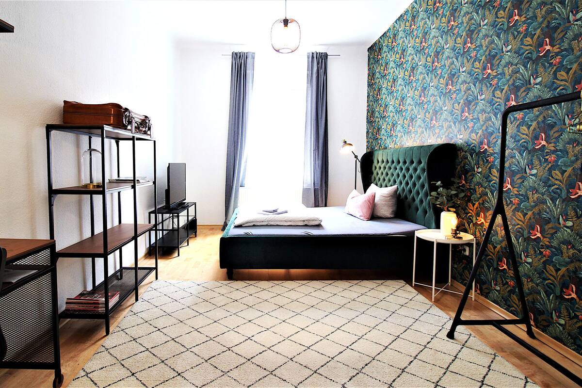 Une chambre à coucher comprenant un lit, un bureau, une chaise, un téléviseur et une armoire.