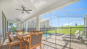 Un patio coperto con piscina, arredi da esterno e vista sul paesaggio circostante.