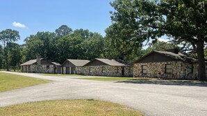 A row of stone buildings with a paved driveway and grassy areas. - Grand lake Cabin 3 @ Stony Point (Jay)