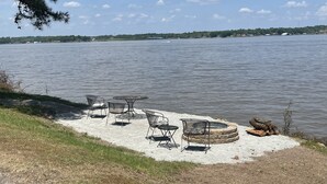 A lakeside patio with outdoor seating and a fire pit. - Grand lake Cabin 3 @ Stony Point (Jay)