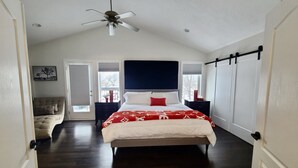 Un dormitorio con cama, ventilador de techo, mesita de noche, cómoda y ventana.