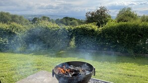 A backyard with a fire pit and a view of the countryside.
