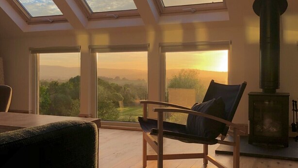A room with skylights, a large window, and a wood-burning stove.