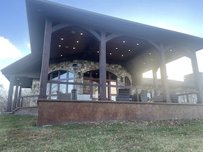 A stone building with a covered patio area, large windows, and a stone wall. - Stony Point Gated Resort All Exclusive: The Lodge, Lakehouse and 4 Cabins (Dennis)