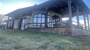 Un edificio de piedra con un amplio ventanal arqueado y un patio cubierto.
