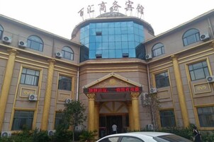 Un edificio con una entrada amplia, columnas y un letrero con caracteres chinos.