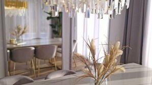A modern dining area with a marble table, a vase with dried plants, and a unique chandelier. - Villa Iva With sea View and Pool (Omis)