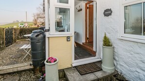 A white building with a door leading to a hallway. There is a sign on the wall that reads "TWINCOTE". - Twincote (Wooler)