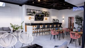 A modern bar area with a sofa, chairs, and a bar counter. - Beautiful 2BR City Center - Renty (Santo Domingo)