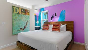 A bedroom with a wooden bed, white bedding, a ceiling fan, and a large wall painting.