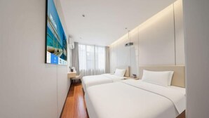 Ein Hotelzimmer mit zwei Betten, einem großen Fenster und einem Bild an der Wand.
