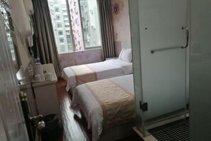 A hotel room with two beds, a small table with a lamp, a window with curtains, and a view of a building outside. - Shenzhen Guihua Hotel (Fubao Subway Station Branch) (Shenzhen)