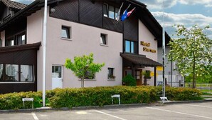 A two-story hotel with a modern facade, a sign reading "Hotel Sterner," and a parking lot in front. - Hotel Sternen (Aarau)