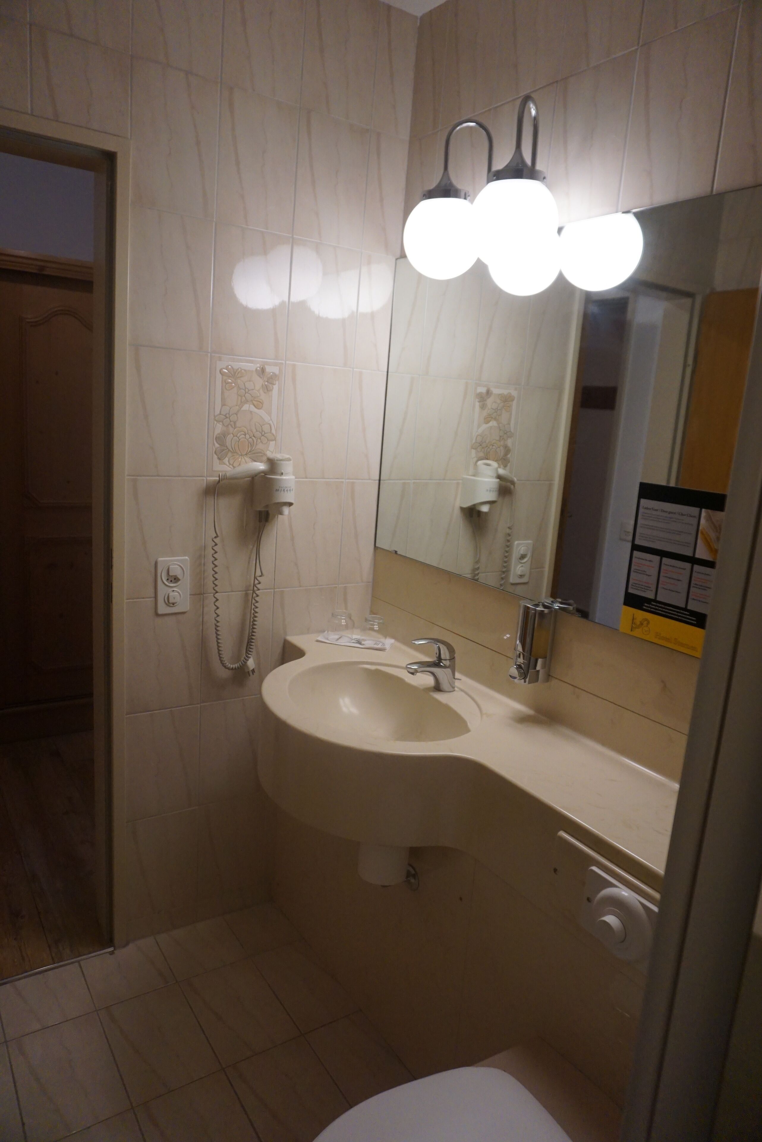 A bathroom with a sink, mirror, and a hairdryer.