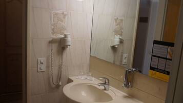 A bathroom with a sink, mirror, and a hairdryer.