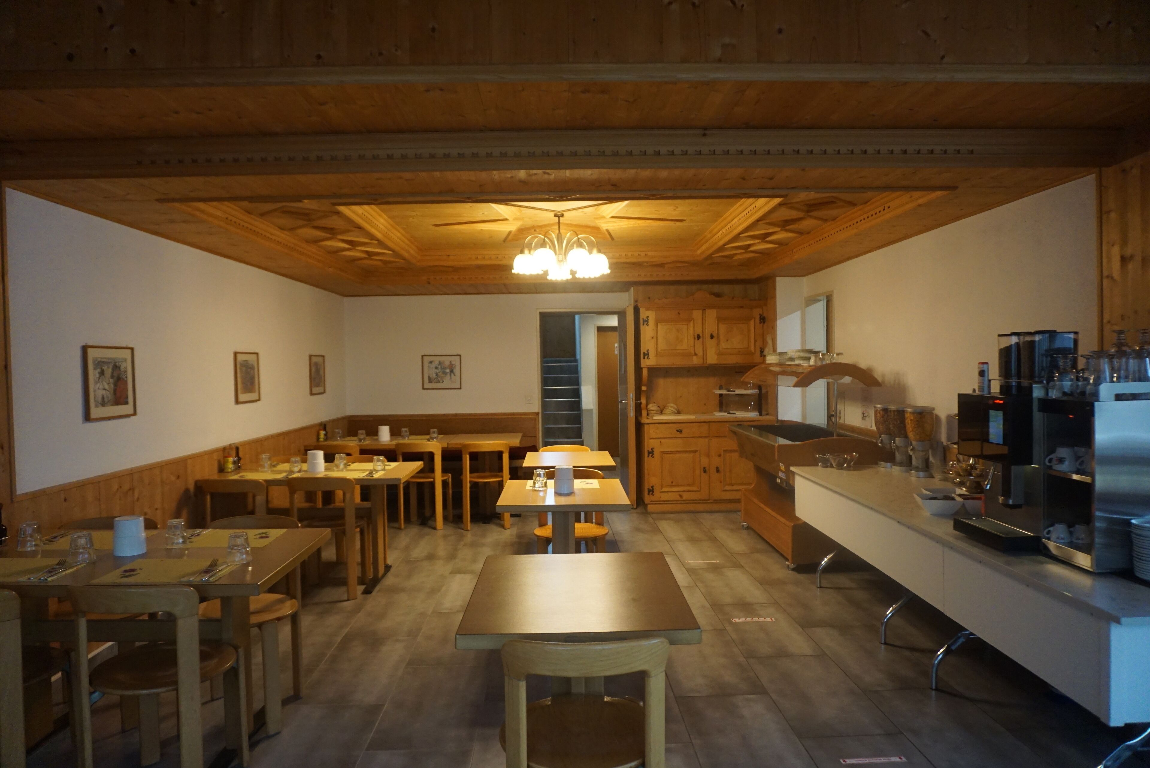 Eine geräumige Küche mit Holzschränken, einer zentralen Kochinsel und einem Essbereich mit Tischen und Stühlen.