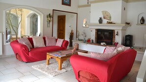Ein Wohnzimmer mit zwei roten Sofas, einem Holztisch und einem Kamin.