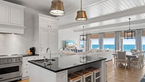 A spacious kitchen with white cabinetry, a large island, and a view of the ocean. - OMG by the Sea: Beachfront in Plantation, Community Pool, One level (St. George Island)