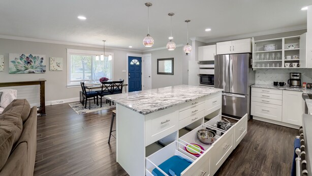 A modern kitchen with white cabinets, a stainless steel refrigerator, and a marble countertop. - Spacious home with King bed - mins to Stadiums (Independence)