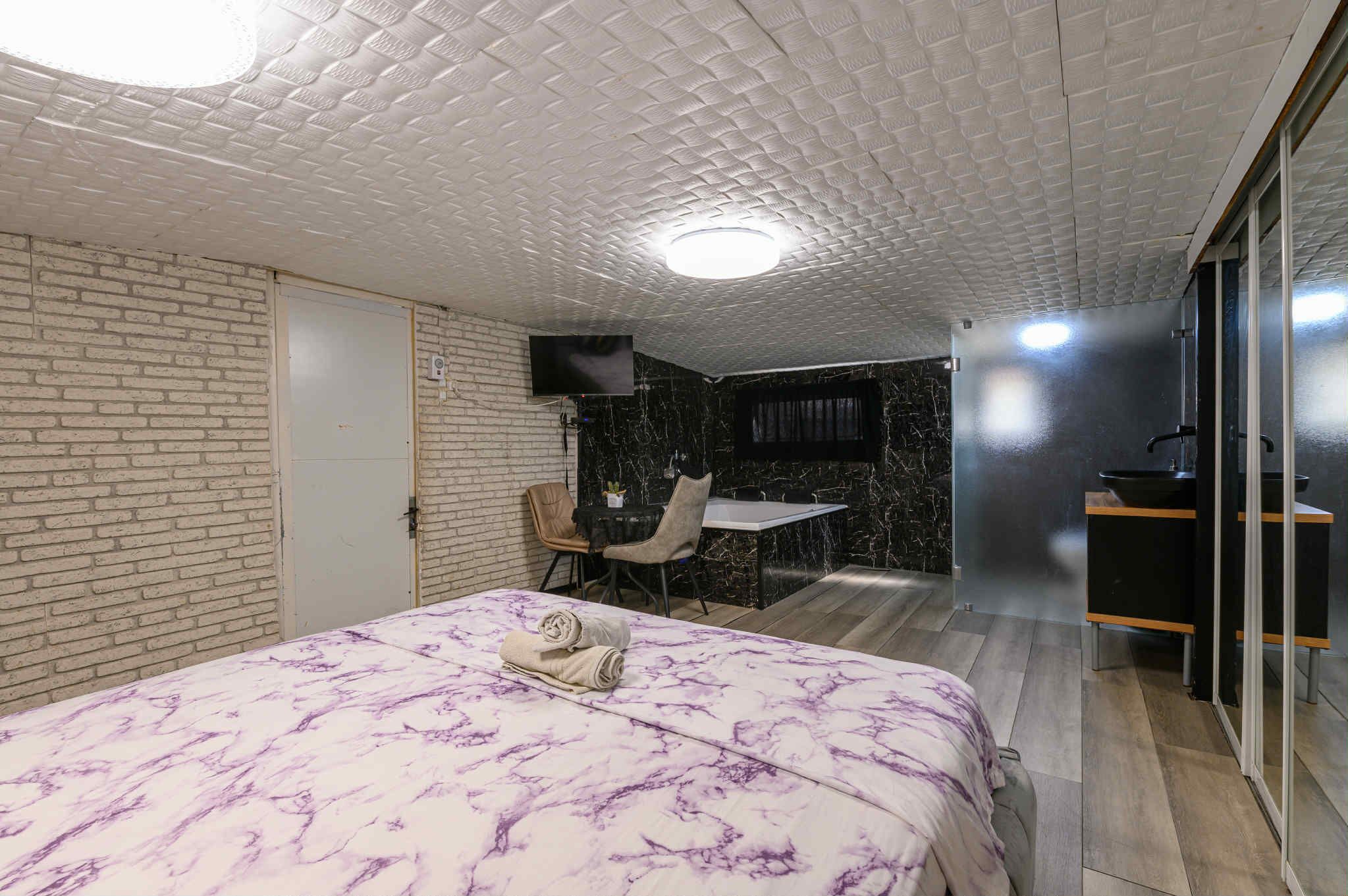 Una habitación de hotel con cama, escritorio y baño.