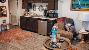 Un salon moderne avec un canapé, une table basse et un tableau accroché au mur.