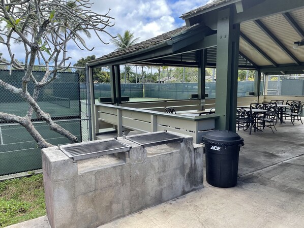 Enjoy dining or socializing in this outdoor seating area with a grill and comfortable tables and chairs.