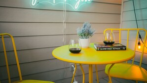 Een gele tafel met een potplant, een boek getiteld 'Island Fruit Remedy' en een glas met een kaars.