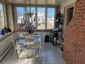 Enjoy meals in this dining area with a glass table and comfortable seating for all.