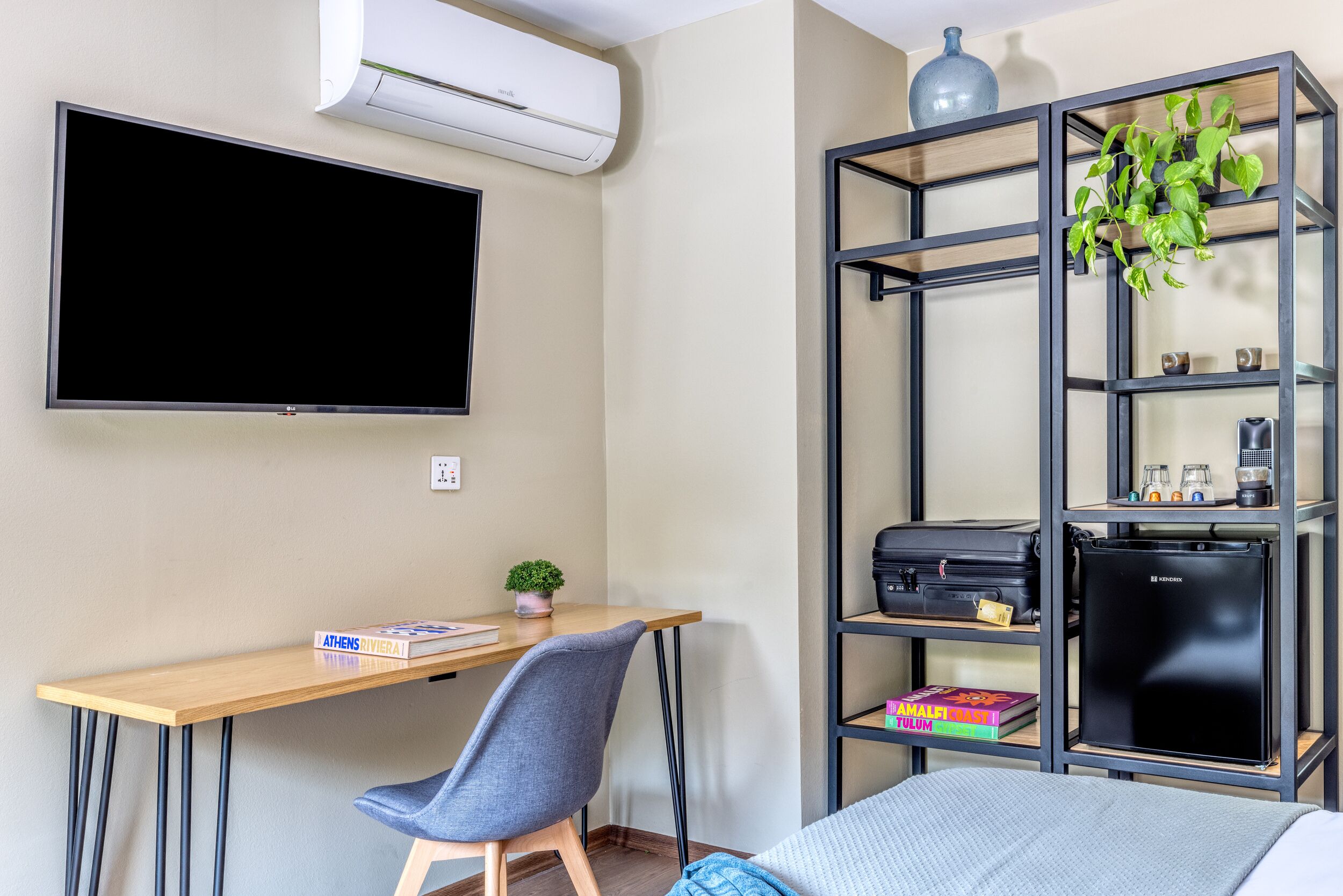 Une pièce comprenant un bureau, une chaise, une télévision, une bibliothèque et un lit.