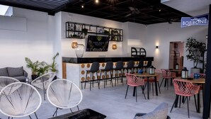 A modern bar area with a counter, seating arrangements, and a sign for 'caffe' BORBONE.