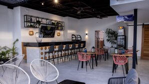 A modern bar area with a counter, seating, and a sign for 'taffer BORBONE'.