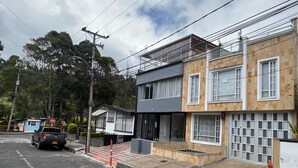 Un immeuble résidentiel de deux étages doté d’un balcon, d’un garage et d’une allée.