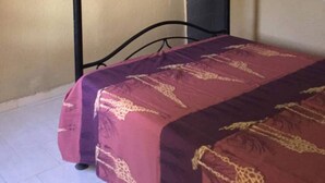 Una cama individual con dosel, un aire acondicionado de pared y una pared lisa.