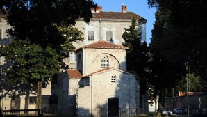 A historic building with a central arched entrance and a smaller attached structure with a tiled roof. - Apartment for 3- 4 people in the center of Pula (Pula)