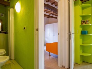 A bathroom with a toilet, a sink, and a green wall. - Casa Francesca by Interhome (Sovicille)
