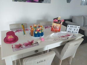 Une table à manger avec un gâteau, une pancarte sur laquelle on peut lire « MARIA, FUTURÉE ÉPOUSE », et un paquet de Doritos.