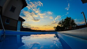 Piscina com vista clara do céu e um edifício ao fundo.