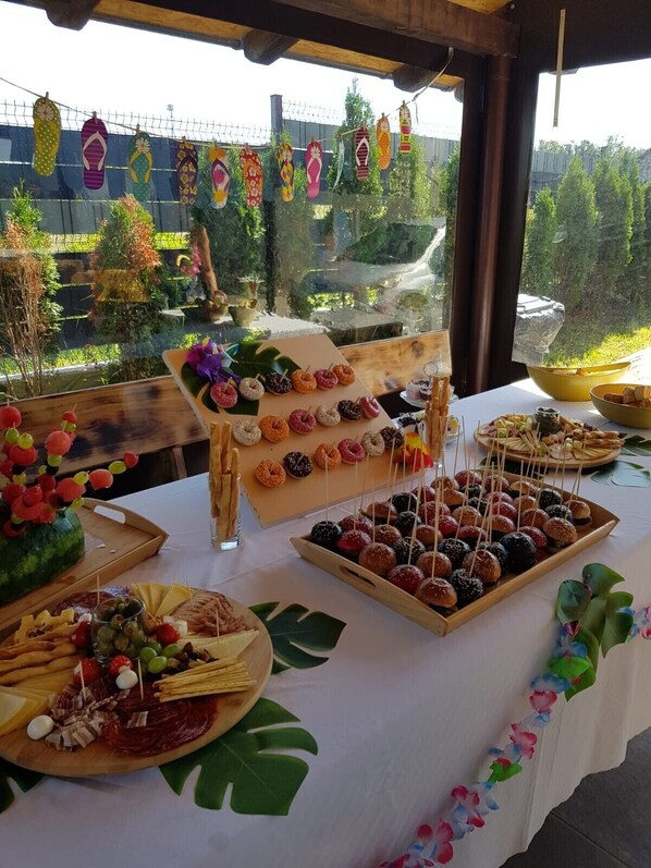 Une table de buffet proposant divers aliments, notamment des beignets, du fromage et de la charcuterie.