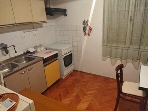 Eine kleine Küche mit Spüle, Herd und Holzboden.