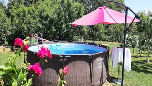An outdoor swimming pool with a metal frame and a pink umbrella. - Apartment Amigo - Two Bedroom Apartment with Terrace (Đurđevac)