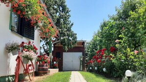 A house with a garage, a pathway, and various plants and flowers. - Apartment Amigo - Two Bedroom Apartment with Terrace (Đurđevac)