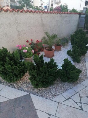 Enjoy a serene garden oasis with a variety of potted plants and shrubs.