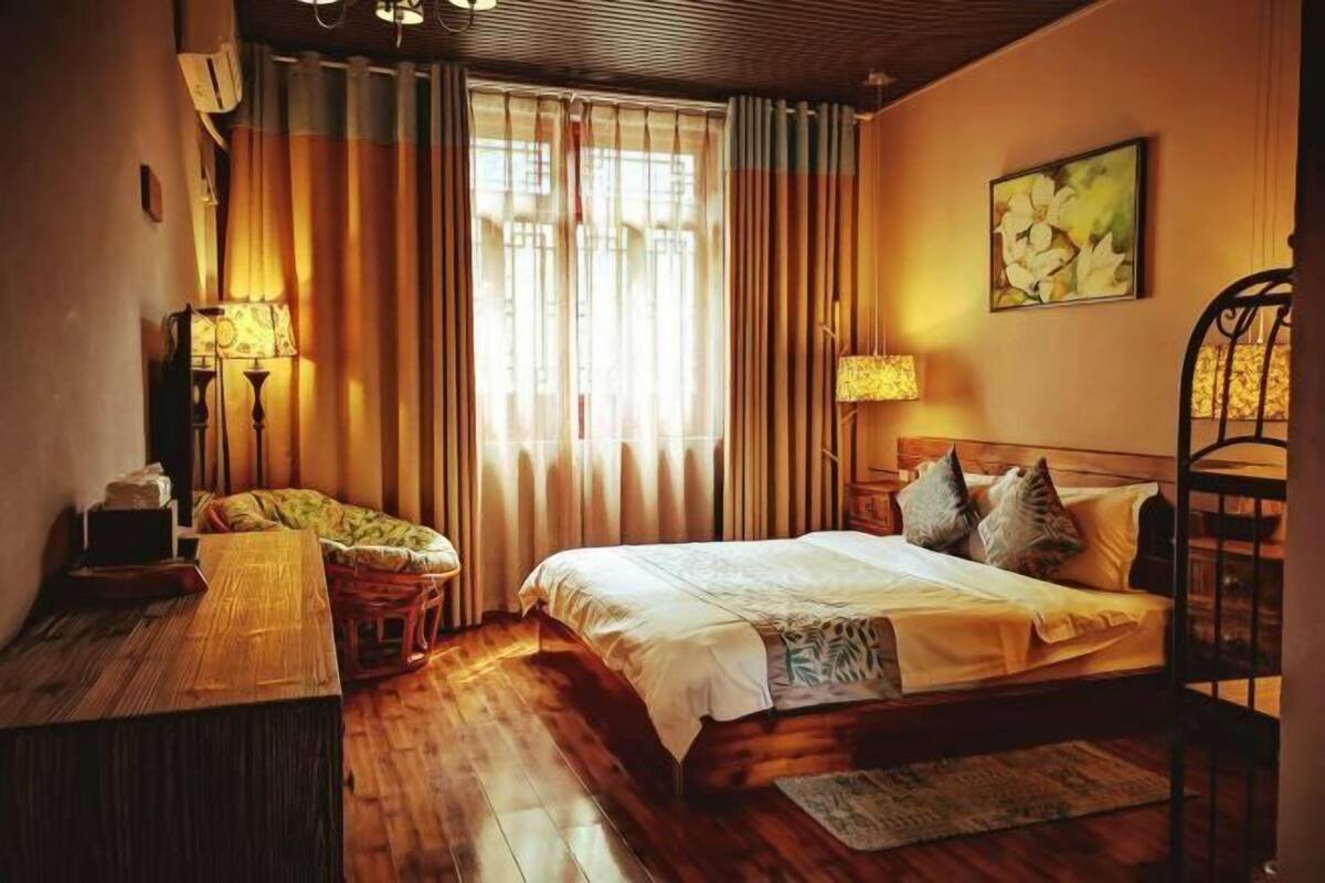 A cozy bedroom with a wooden bed, a desk, and a chair.