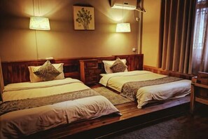 A room with two beds, wooden headboards, a wall-mounted lamp, and a framed picture. - Fanhua Courtyard (Chongqing)