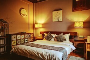 A neatly arranged bedroom with a large bed, two bedside lamps, a wooden headboard, and a decorative cabinet. - Fanhua Courtyard (Chongqing)
