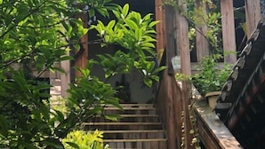 A wooden staircase leading to a covered area with a wooden railing. - Fanhua Courtyard (Chongqing)
