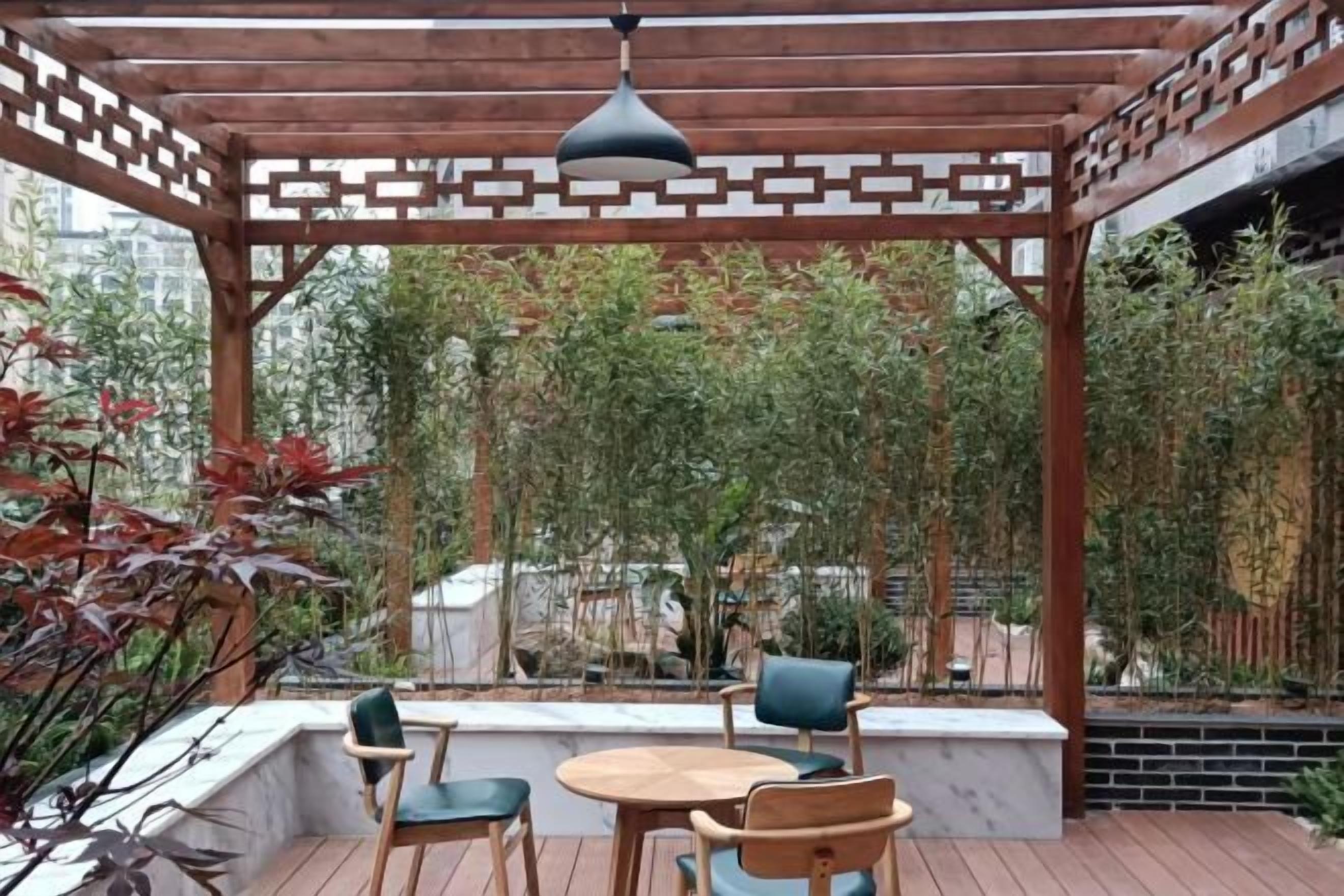An outdoor patio with wooden furniture and a pergola structure.