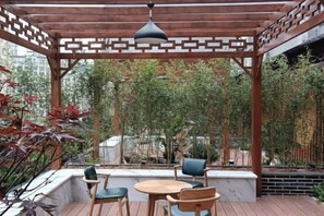 An outdoor patio with wooden flooring, a pergola, and seating. - Haolilai Garden Hotel (Sanming)