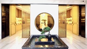 A lobby with a central round mirror, a black marble fountain, and golden decor. - Haolilai Garden Hotel (Sanming)