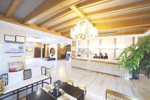 A hotel lobby with a reception desk, seating area, and a chandelier. - Haolilai Garden Hotel (Sanming)